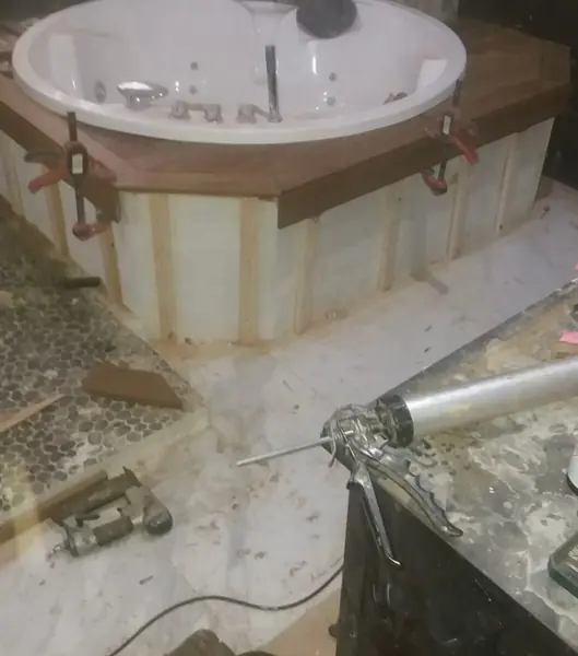 Bañera de hidromasaje con la encimera de teka encolándose con sargentos y el rastrelado de listones a la vista
