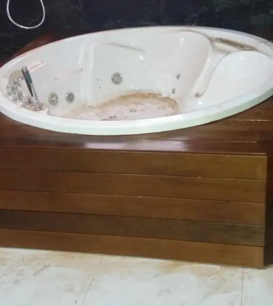 Frente de la bañera revestido en tablas horizontales de teka, con la encimera terminada