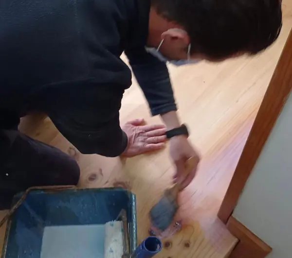 Aplicando el producto con brocha sobre la madera recién lijada