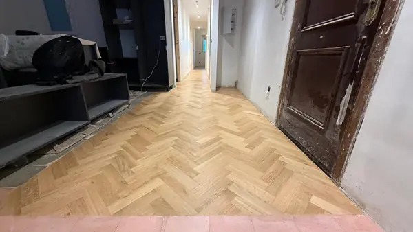 Recibidor terminado con la espiga de roble continuando por el pasillo