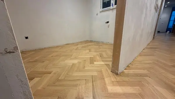 Habitación con suelo de roble en espiga junto al pasillo