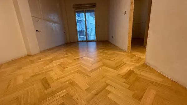 Dormitorio con balcón y suelo de roble en espiga terminado