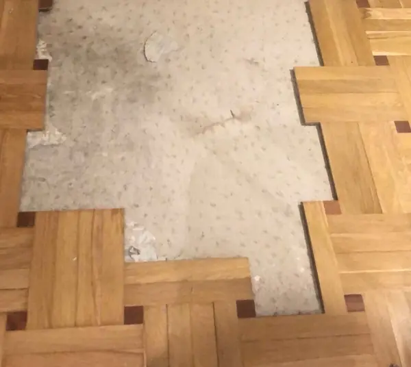 Parquet de tablillas con una zona entera perdida y la solera a la vista