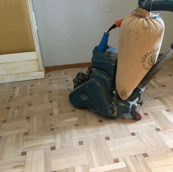 Lijadora de suelos sobre el parquet, ya con la madera nueva y la antigua igualadas