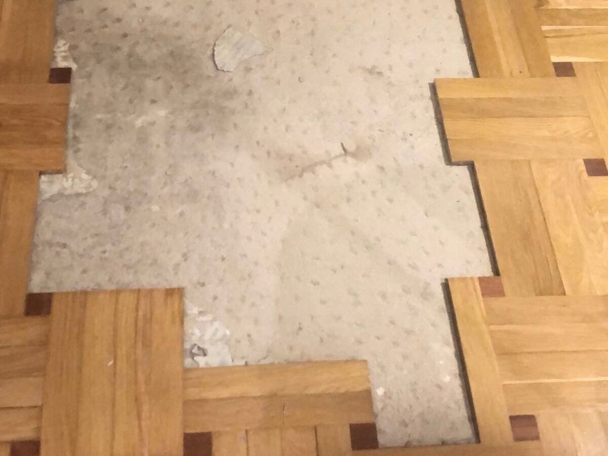 Parquet mosaico con piezas perdidas y la solera a la vista