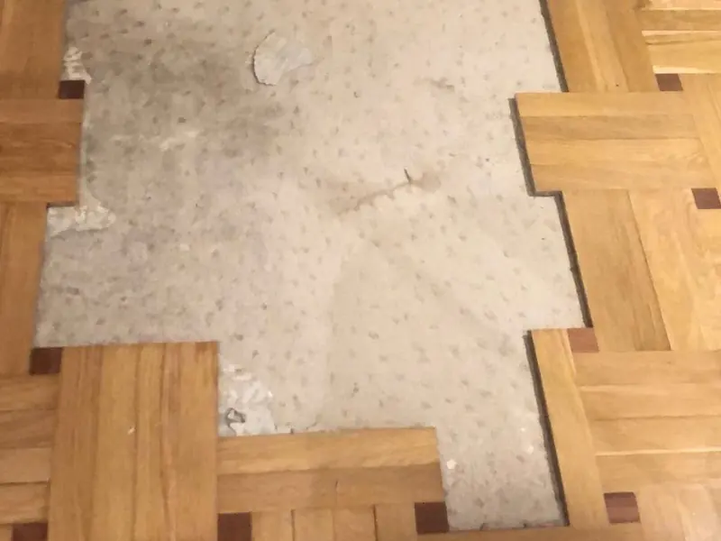 Parquet mosaico con piezas perdidas y la solera a la vista