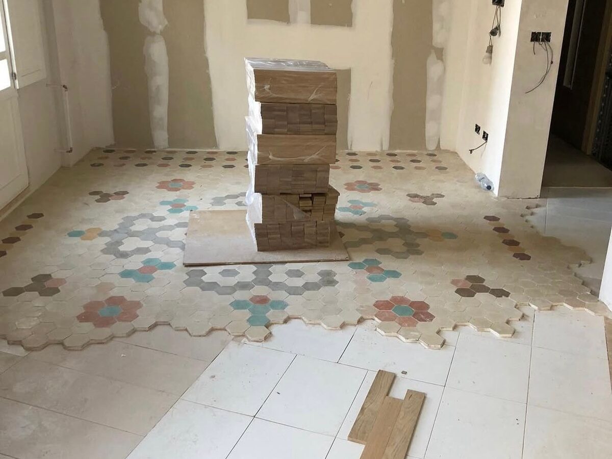Estancia en obras con la baldosa hidráulica original y los tablones preparados