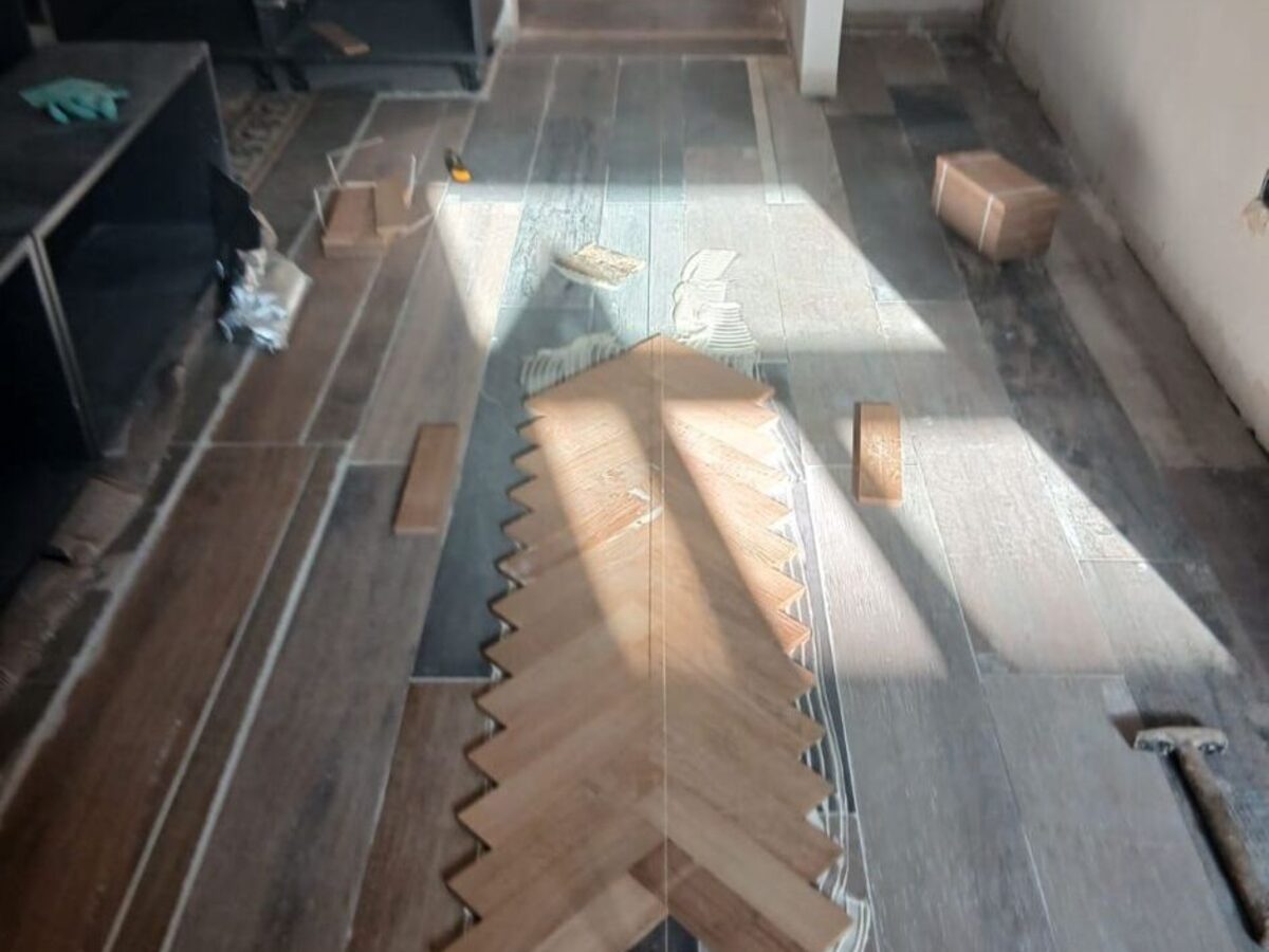 Faja de parquet en espiga a medio colocar en el pasillo