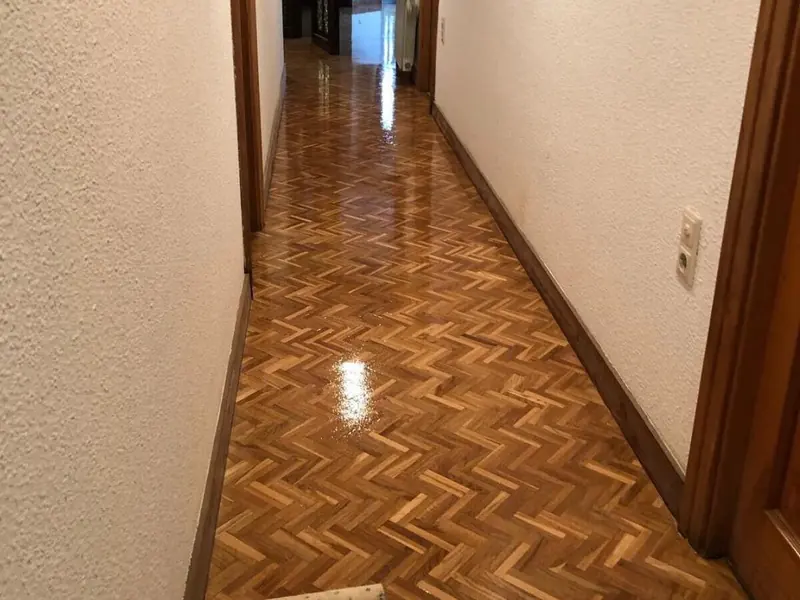 Pasillo con el parquet en espiga lijado y recién barnizado